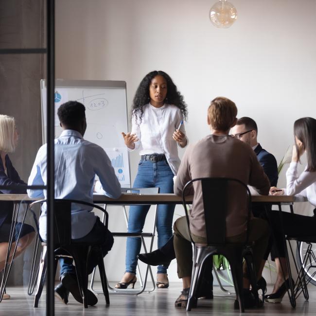 A marketer giving a presentation to a group of colleagues in an office